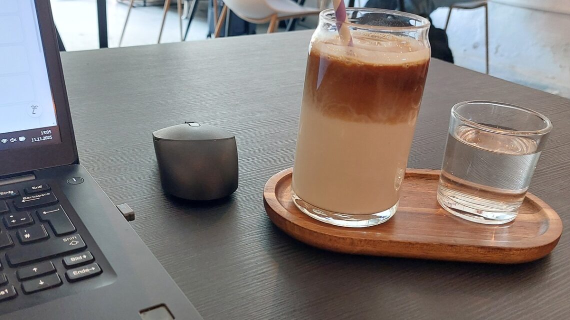 Coworking Café mit Computer und Kaffee als Symbolbild für Motivation und Produktivität (richtige Arbeitsumgebung schaffen)