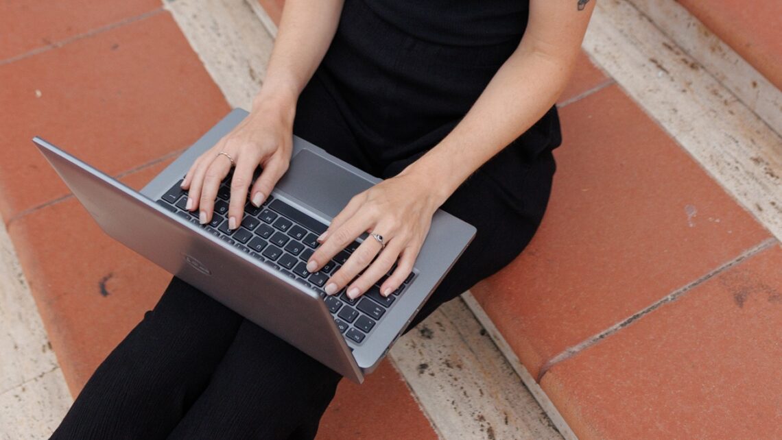 Frau arbeitet am Laptop: Symbolbild für das Überwinden von Prokrastination